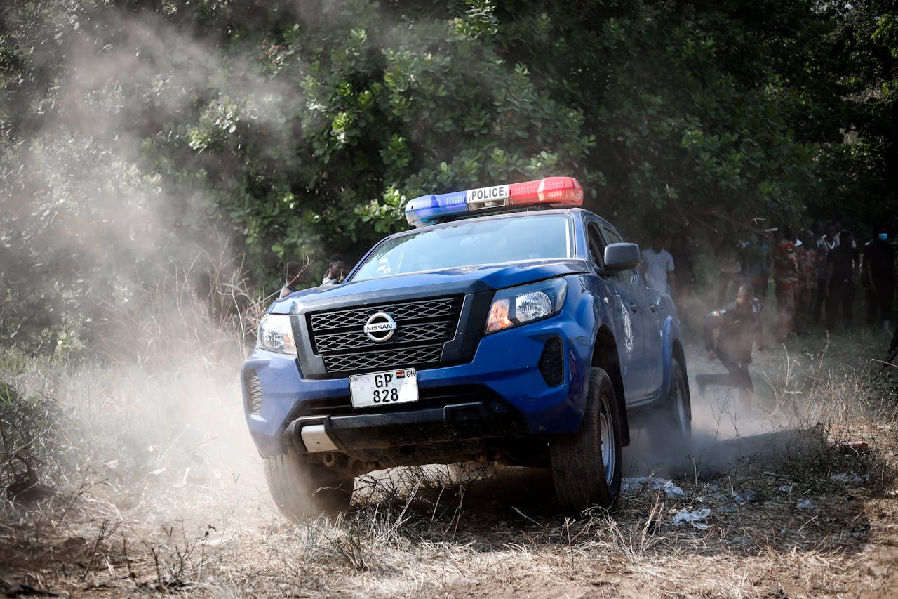 A police vehicle navigates offroad terrain in Kintampo, Ghana, showcasing law enforcement readiness.